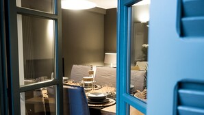 A compact room with a dining table set for two, a chair, and a lamp. - Le Logge apartment (Parma)