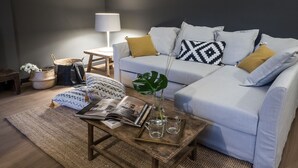A modern living room with a sofa, coffee table, and a lamp. - Le Logge apartment (Parma)
