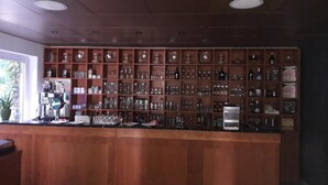 A bar area with a wooden counter and shelves filled with glassware and bottles. - Hotel Rosengarten (Naunhof)