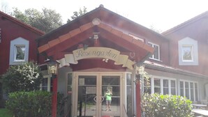 A building with a sign reading "Rosengarten" and a glass door entrance. - Hotel Rosengarten (Naunhof)