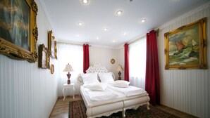 Un dormitorio con una cama grande, una mesita de noche, una lámpara y un cuadro en la pared.