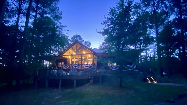 A wooden cabin with a porch, surrounded by trees. - Peace of Heaven - close to everything you'll want to see and do! (Broken Bow)