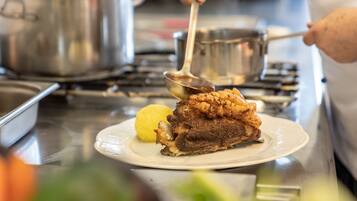 A chef serving a dish with a spoon.