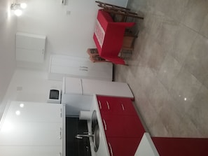 A modern kitchen with white cabinets, a red countertop, and a built-in oven. - House Sojat - great apartment with sea view (Senj)