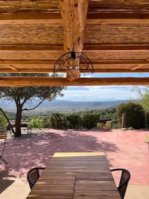 Une terrasse en bois, située à l’extérieur, qui offre une vue sur la campagne.