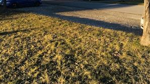 A two-story house with a sloped roof, a driveway, and parked cars. - La Grange (Charmey)