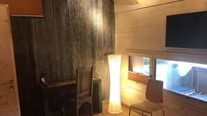 A room with a bed, a desk, a chair, a large window, and a TV mounted on the wall. - La Grange (Charmey)