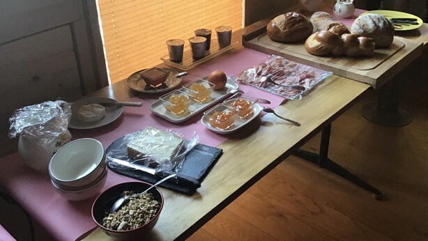 A table with various food items including bread, pastries, and condiments. - La Grange (Charmey)