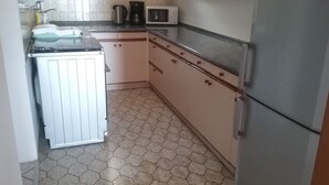 Eine kompakte Küche mit Kühlschrank, Mikrowelle und einer kleinen Spüle.