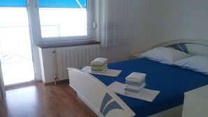 Ein Schlafzimmer mit einem Bett, einem Fenster und einer Heizung.