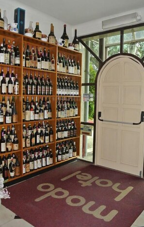 A wine cellar with shelves of wine bottles and a welcome mat with "happy new year" text.