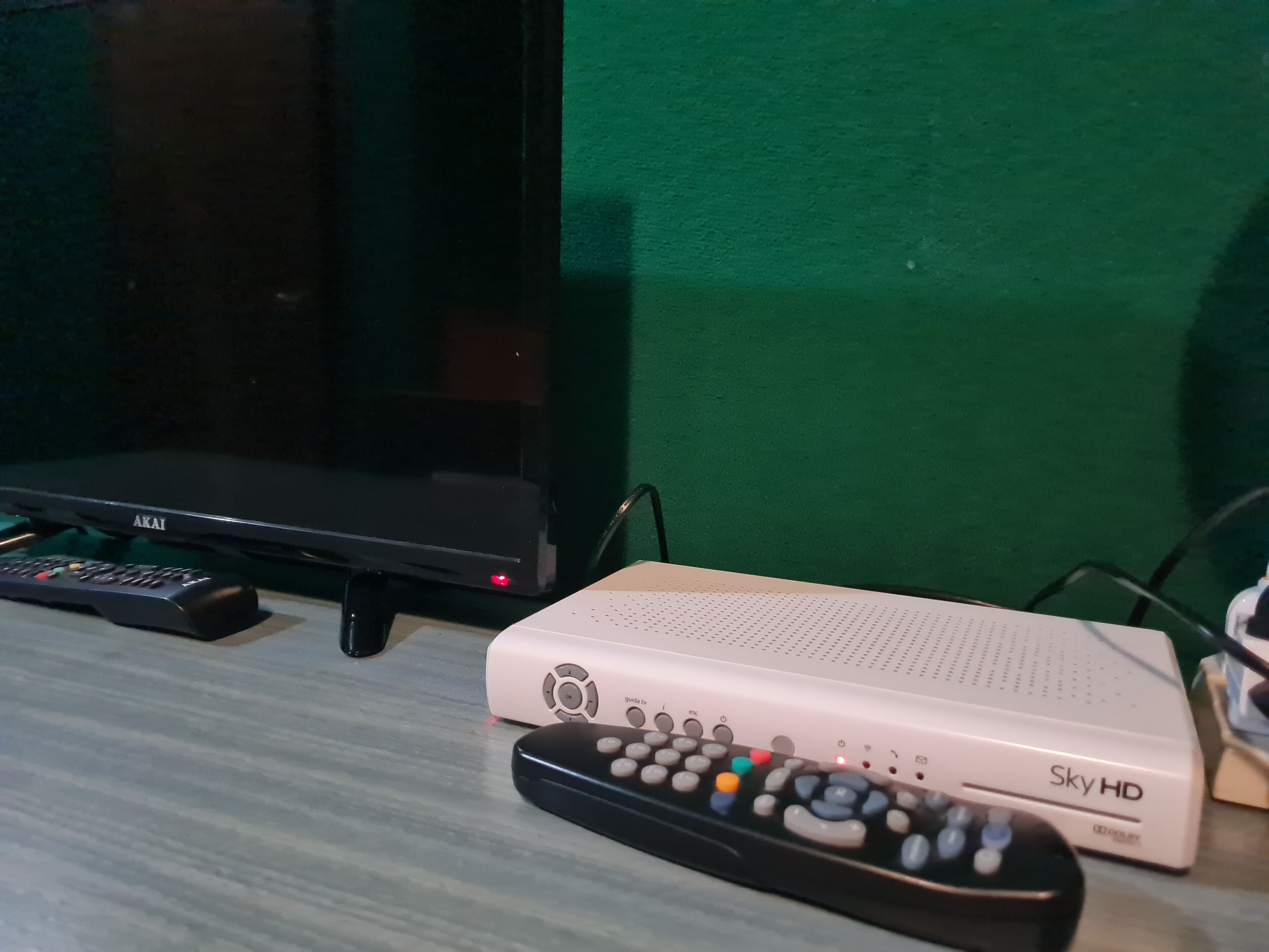 Un televisor, un decodificador Sky HD y un control remoto sobre una mesa.