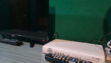 Un televisor, un decodificador Sky HD y un control remoto sobre una mesa.