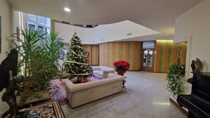 Un vestíbulo amplio con un árbol de Navidad, un sofá y un piano.
