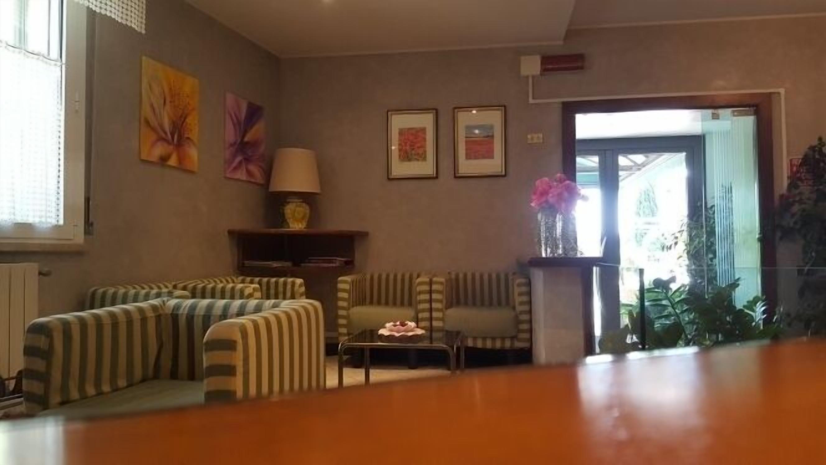 A living room with striped sofas, a coffee table, and framed pictures on the wall.