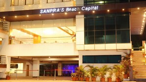 SANPRA'S Beach Capital with a modern facade, a visible entrance, and potted plants near the entrance. - Bay View Hotel (Visakhapatnam)