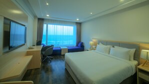 A hotel room with a bed, desk, chair, and a television. - Bay View Hotel (Visakhapatnam)
