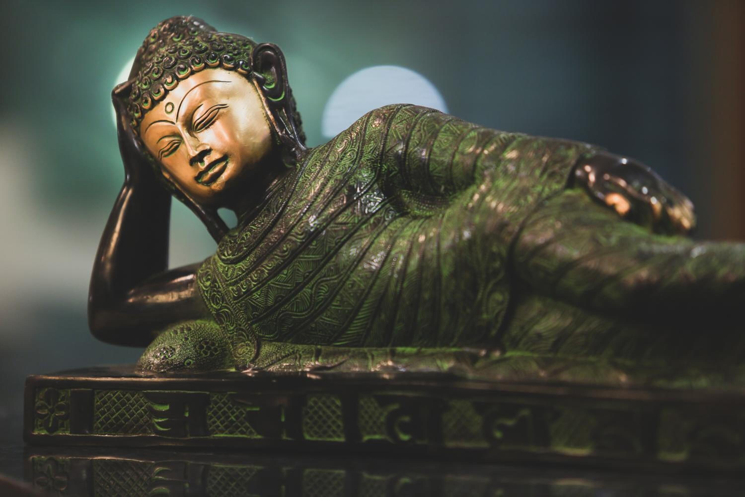 A Buddha statue with intricate patterns and a serene expression, placed on a pedestal.