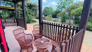 A covered patio area with wicker furniture and a checkered floor.
