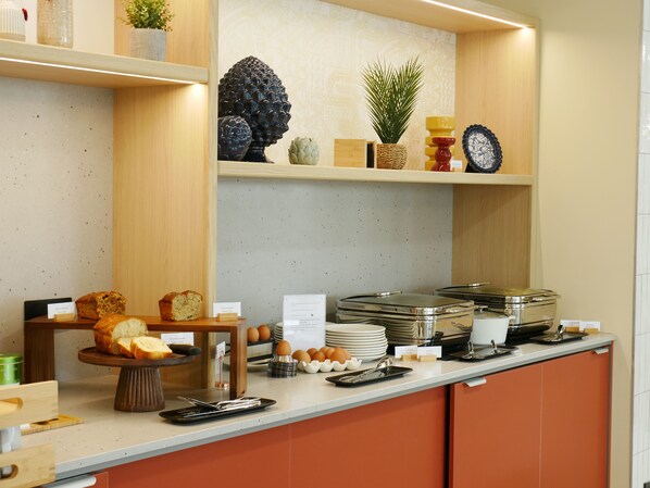 Un buffet de petit-déjeuner comprenant du pain, des œufs et diverses garnitures.