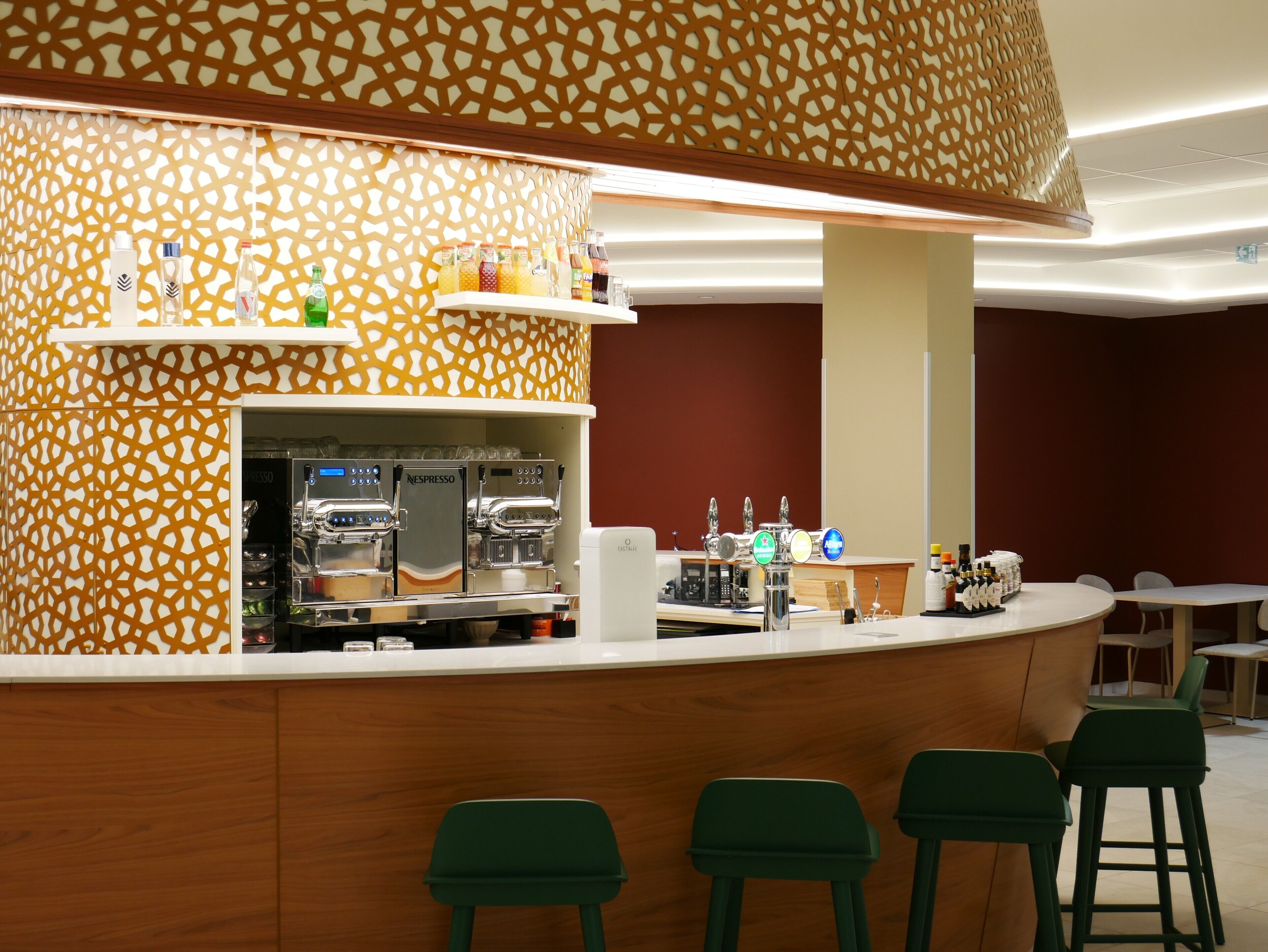 A bar area with a counter, two espresso machines, and a selection of beverages.