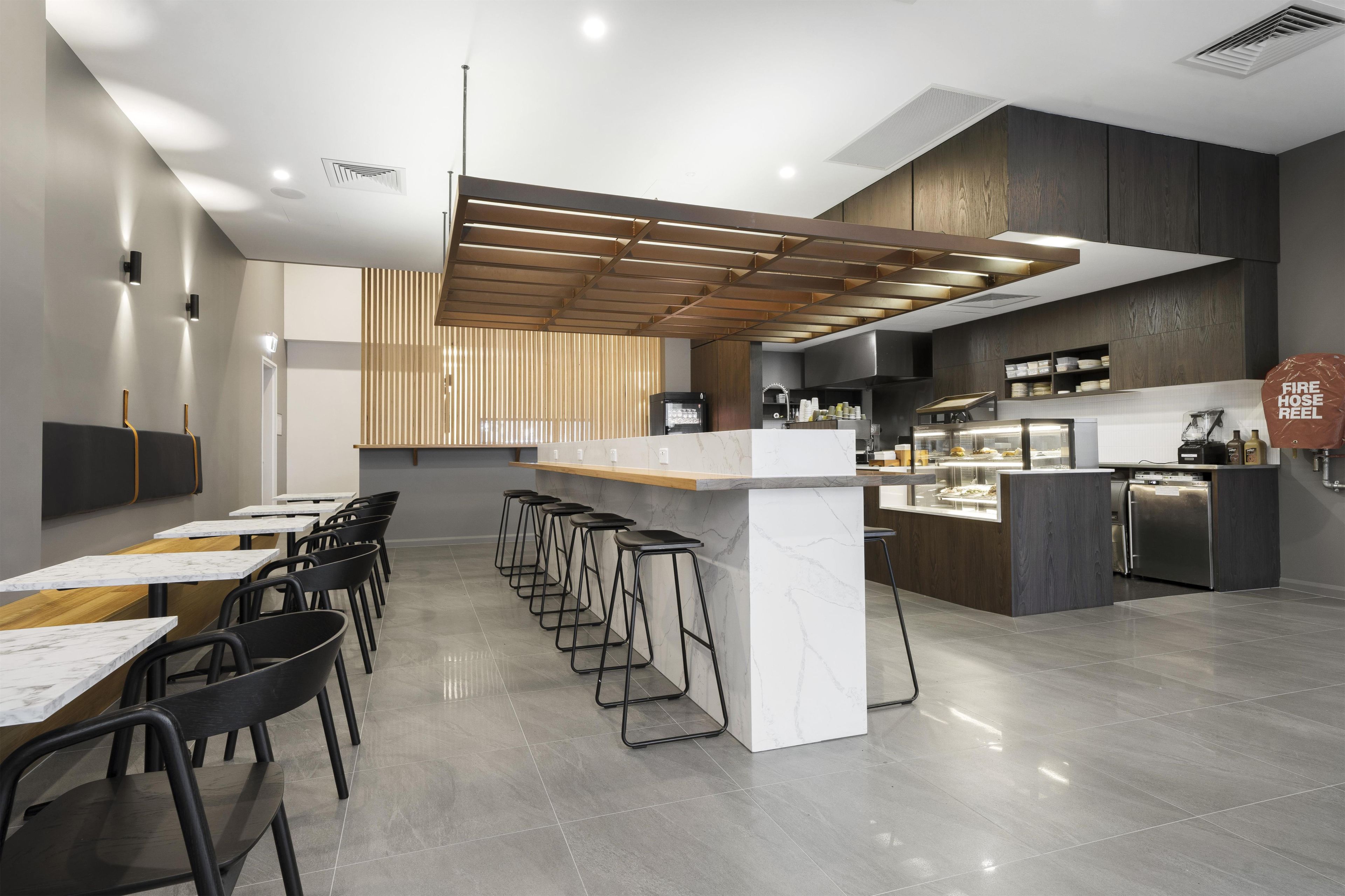 Et moderne restaurantinteriør med barområde, siddepladser og et køkken.