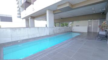 An indoor swimming pool with a tiled floor and a pool depth sign indicating 1.3 meters.
