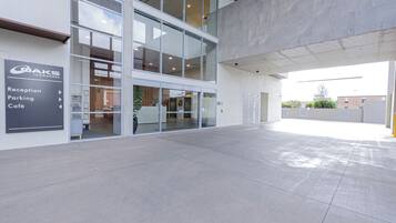 Un edificio moderno con recepción, estacionamiento y cafetería.