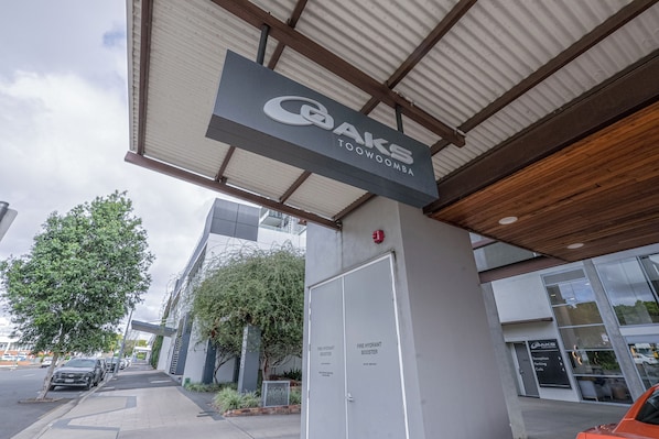 A parking structure with a sign for 'OAKS TOOWOOMA' and a fire hydrant booster sign. - Oaks Toowoomba Hotel (Toowoomba)