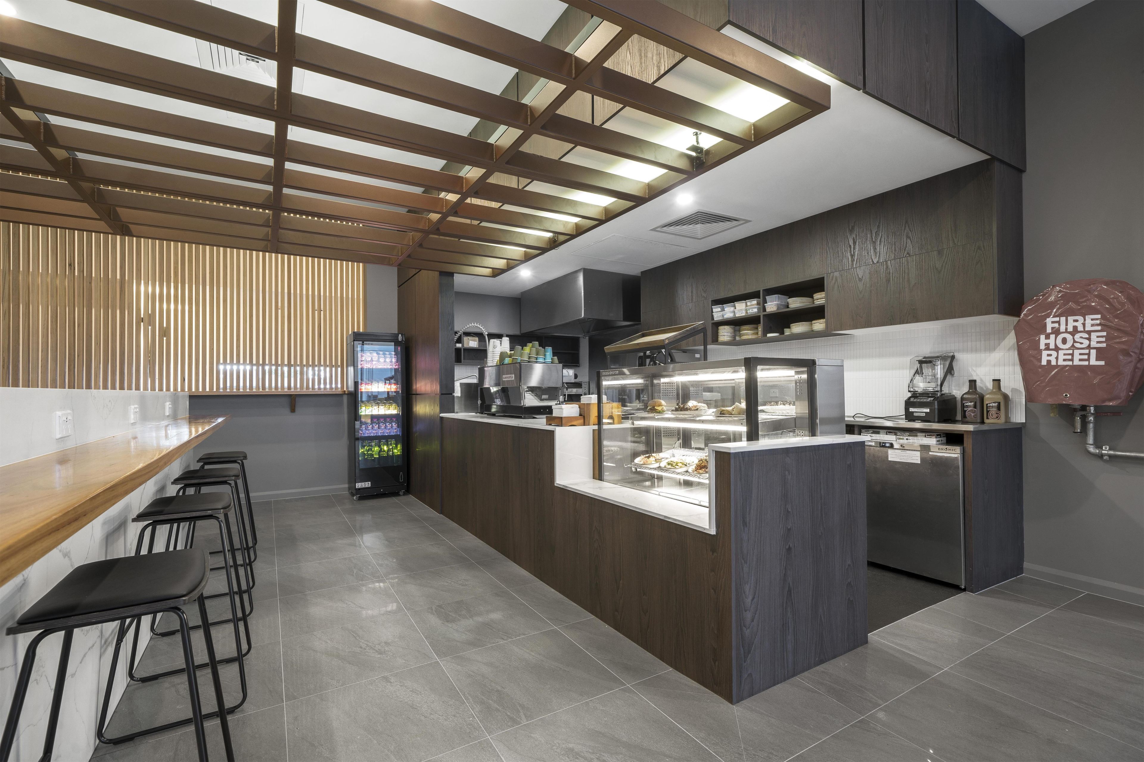 Una cucina moderna con isola centrale, sgabelli da bar e distributore automatico.