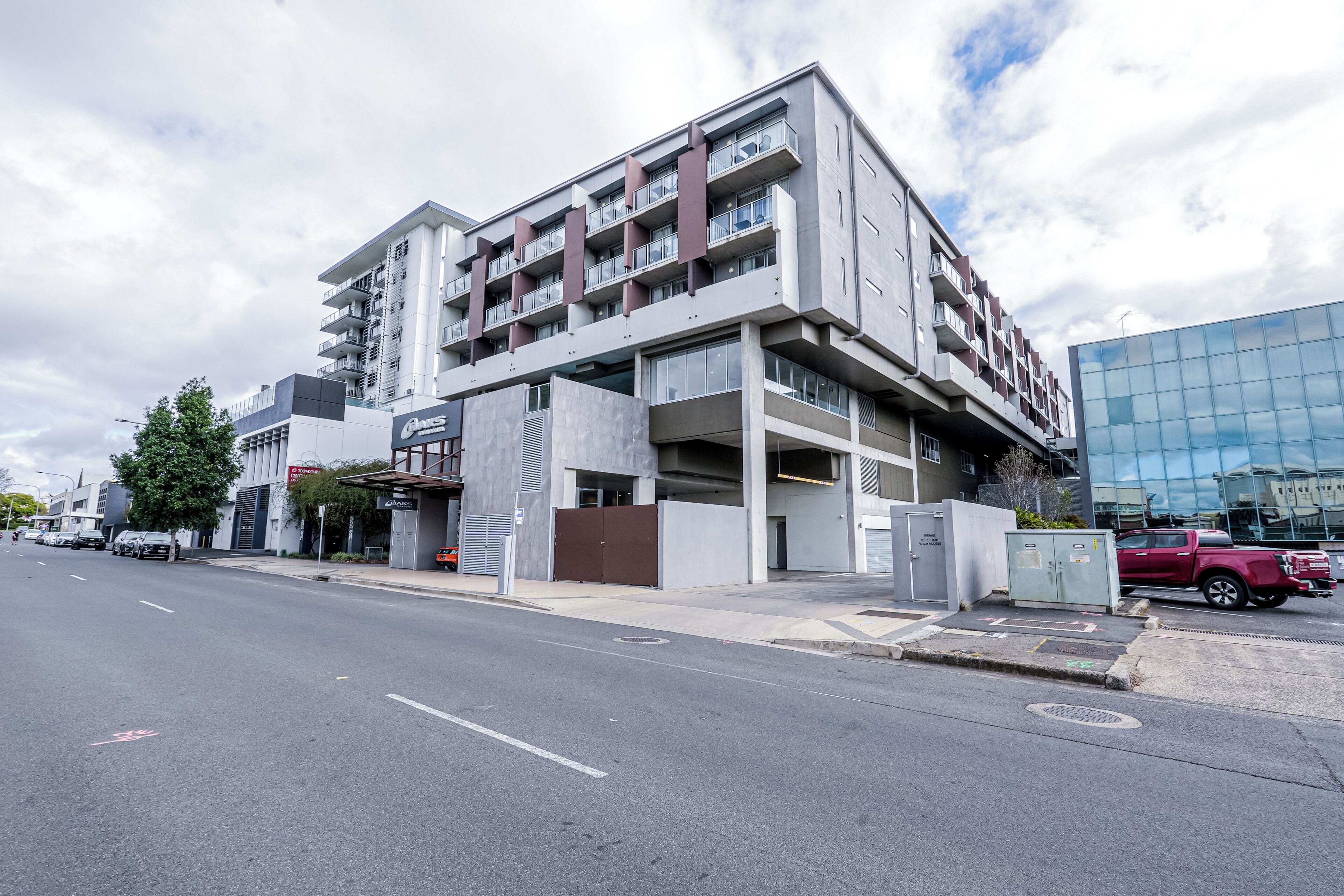A multi-story building with a modern architectural design, featuring a mix of balconies and large windows.