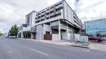 A multi-story building with a modern architectural design, featuring a mix of balconies and large windows.