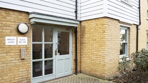 A building entrance with a white door, a brick wall, and a sign indicating 'Bingley Court Flats 96-109'. - Bingley Court (Canterbury)