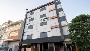 Een modern gebouw met een bordje waarop 'Treebo Kings Orchid' staat.