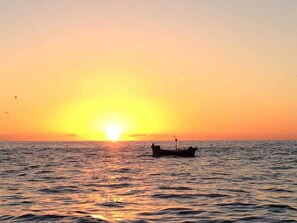 A boat on calm water during sunset.