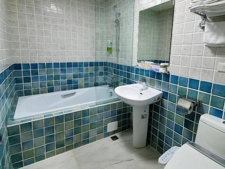 A bathroom with a bathtub, sink, and toilet.