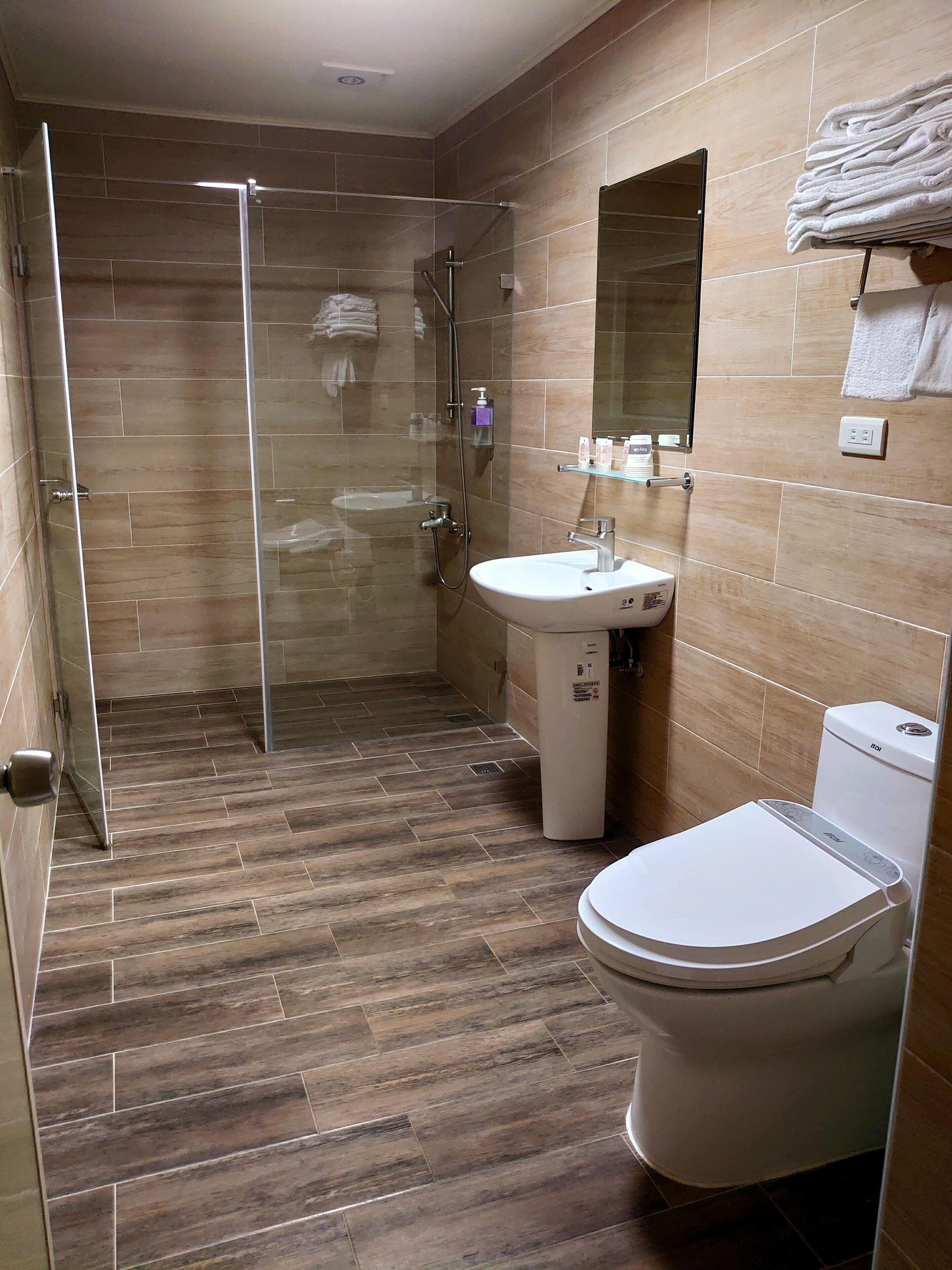 A bathroom with a shower, toilet, and sink.