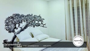A hotel room with a bed, a wall-mounted tree decoration, and a curtain. - Homely Stay Balana Kapolla (Mawanella)