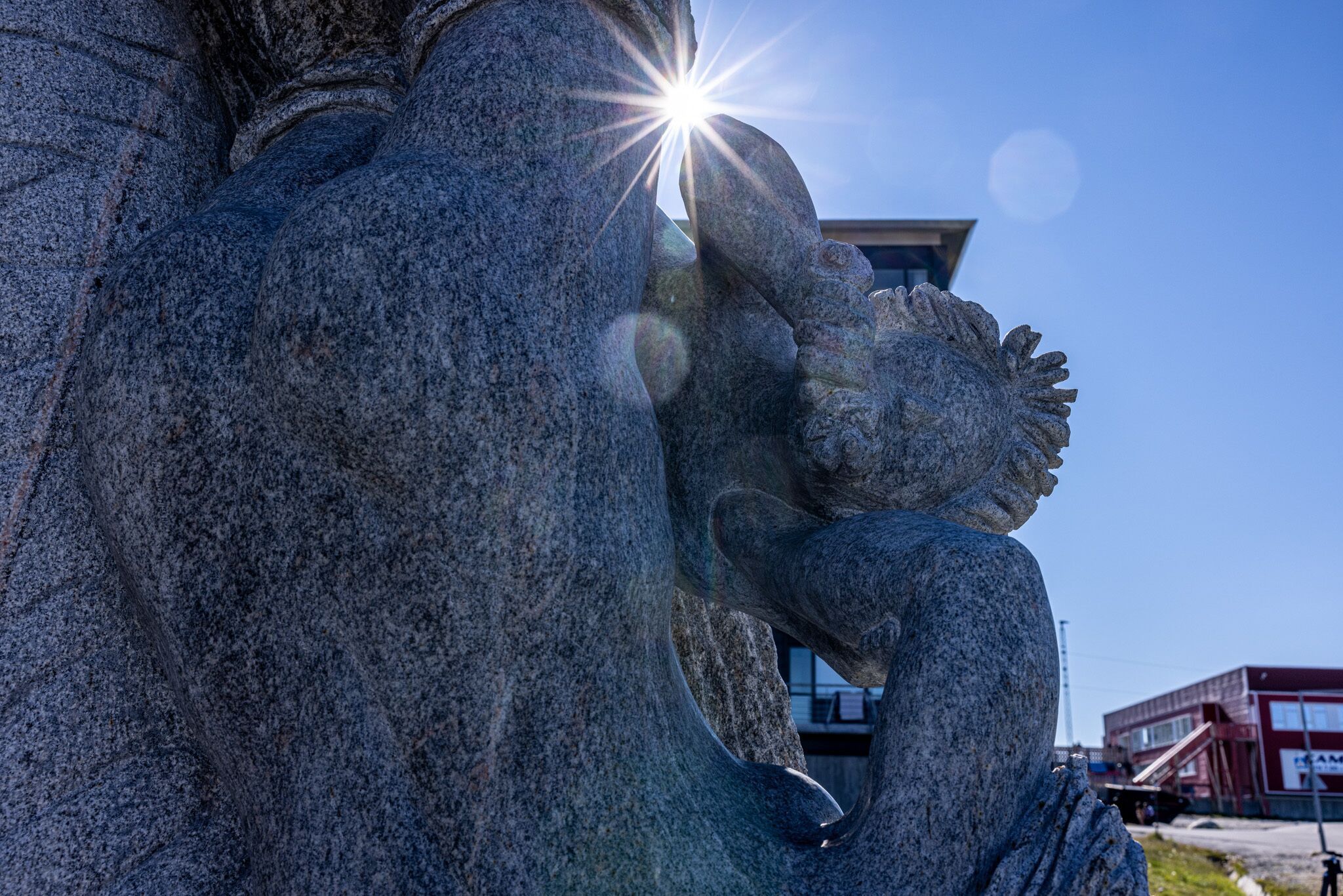A stone sculpture with a bright light source behind it.