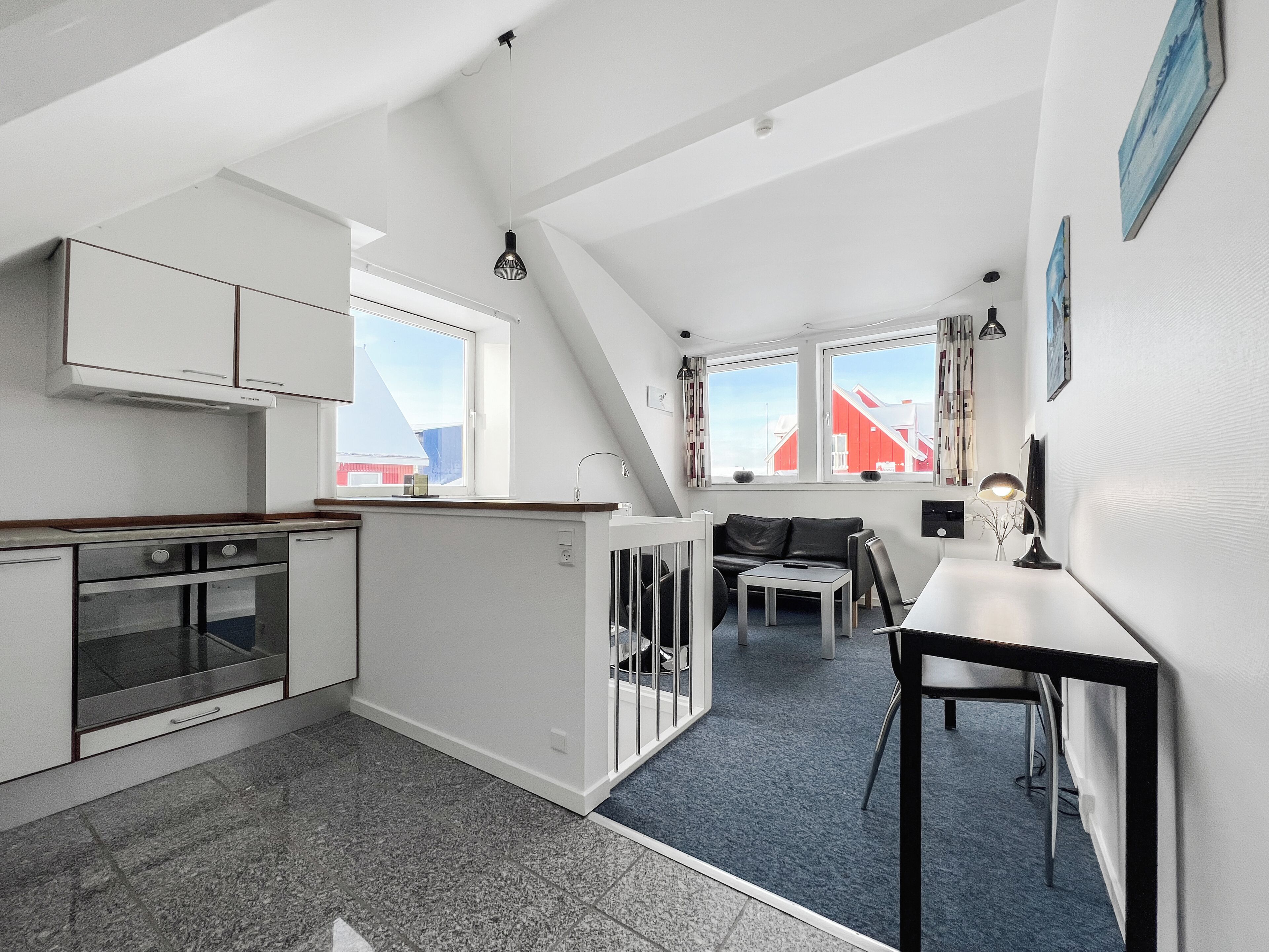 Een kleine keuken met een eethoek, een bank en een tafel.