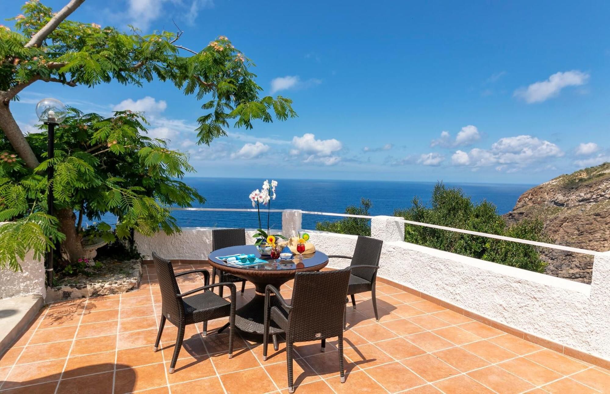 Una terraza con mesa y sillas con vistas al mar.