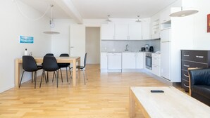 A modern apartment with a dining area, kitchen, and living space. - Hotel Nordbo City (Nuuk)