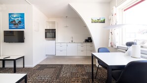 A modern kitchen with white cabinets, a built-in oven, and a coffee machine. - Hotel Nordbo City (Nuuk)