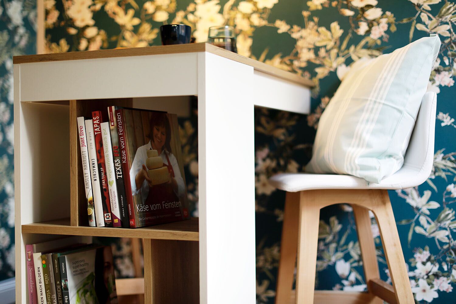 Une bibliothèque remplie de livres et une chaise avec un coussin.