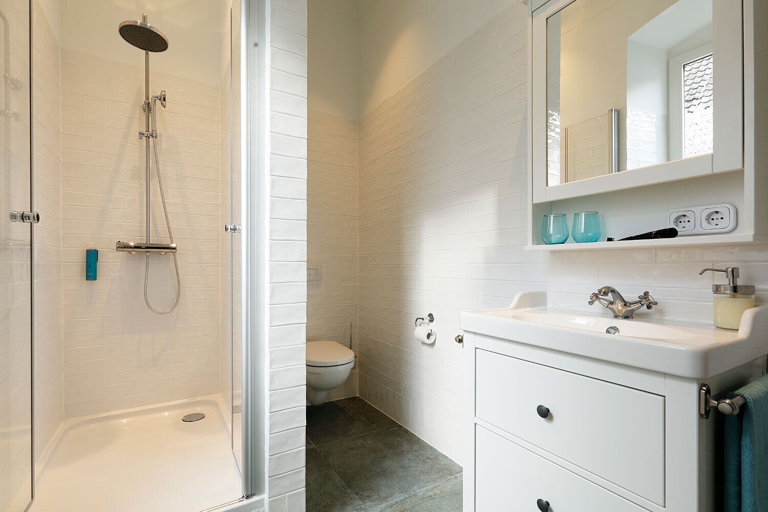 A bathroom with a shower, toilet, and sink.