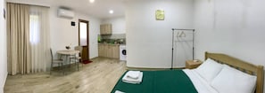 A hotel room with a bed, a desk, a chair, a washing machine, and a drying rack. - Guest House Beautiful Tbilisi (Tbilisi)