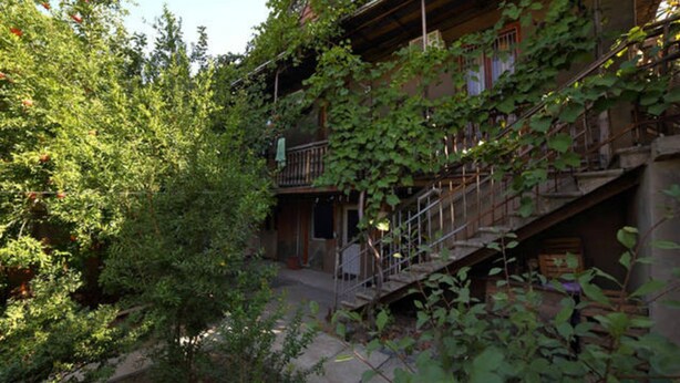 Un bâtiment de style rustique doté d’un balcon et d’un escalier menant à un deuxième étage.