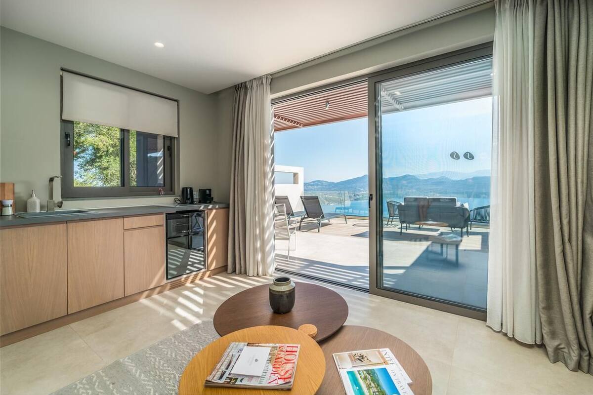 A modern kitchen with a large window, a dining area with a round table, and a view of the outdoors.