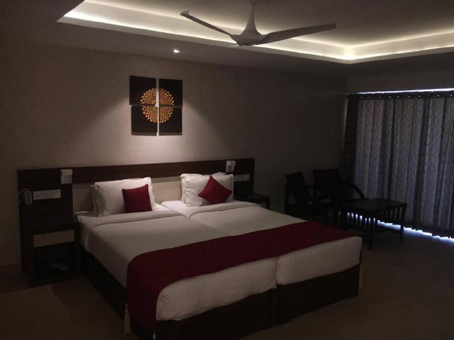 Una habitación de hotel moderna con una cama grande, un ventilador de techo y vistas a la ciudad.