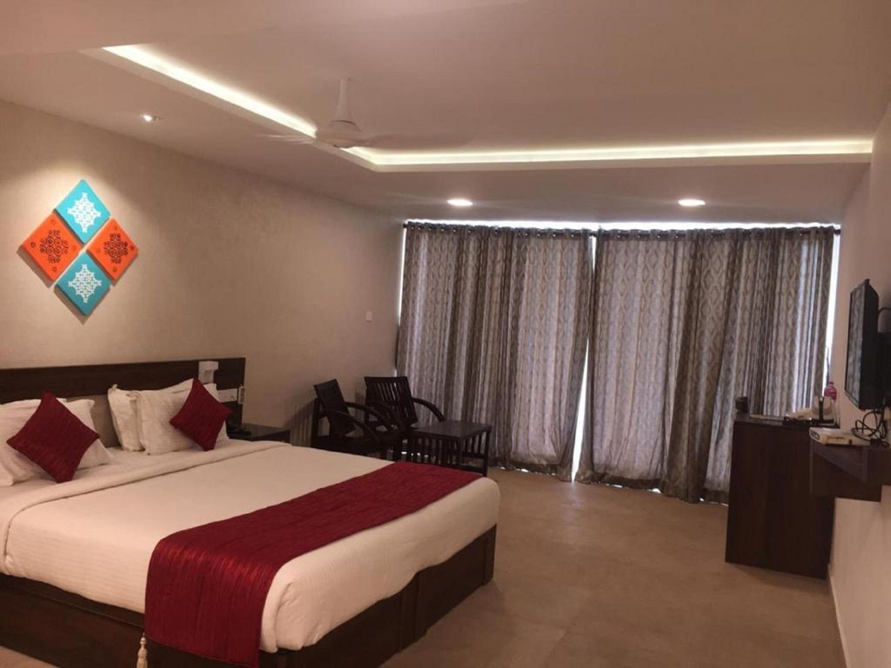 Una habitación de hotel con una cama grande, un escritorio, una silla y un televisor.